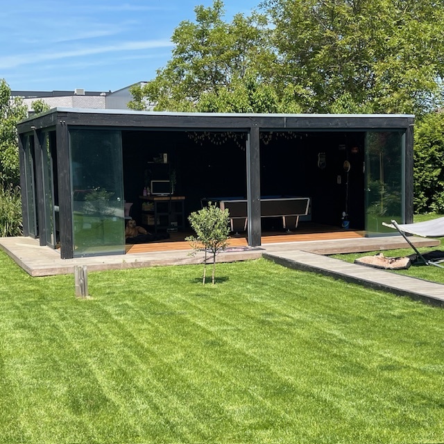 Modernes Gartenhaus mit schönen Glastüren und Terrasse